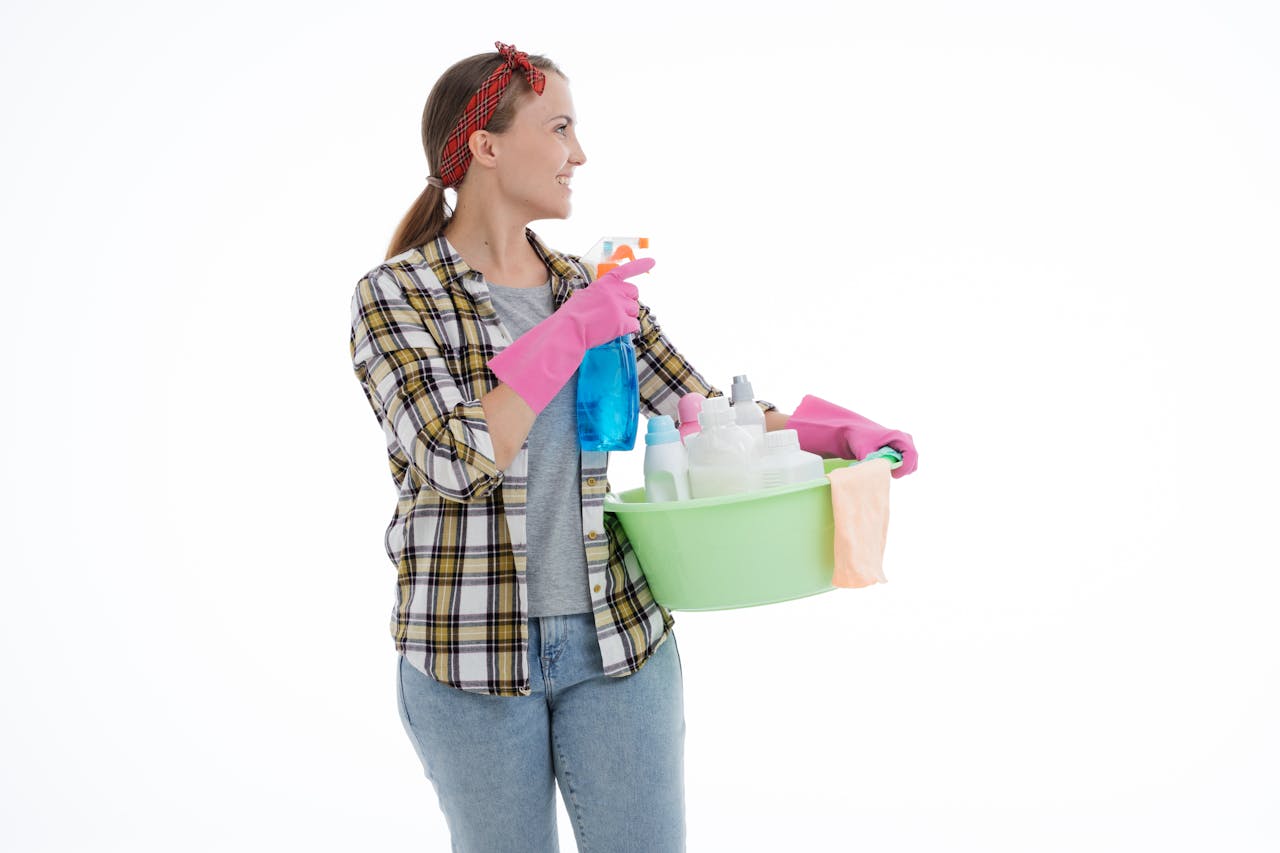 services-03 Woman holding cleaning supplies in a studio shot with a white background. Perfect for housekeeping themes.