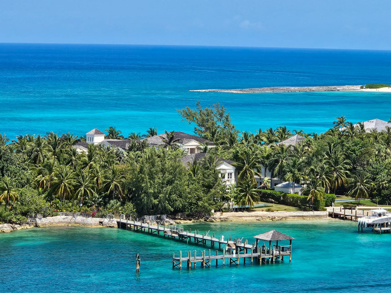 Stunning ocean and villa view in Nassau, Bahamas, featuring vibrant turquoise waters and lush palm trees.